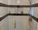 Shower remodel with intricate black and white tile work