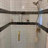 Shower remodel with intricate black and white tile work