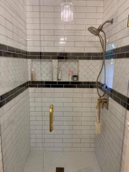Shower remodel with intricate black and white tile work