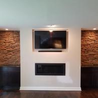 Fireplace with built in TV space and stone detailing