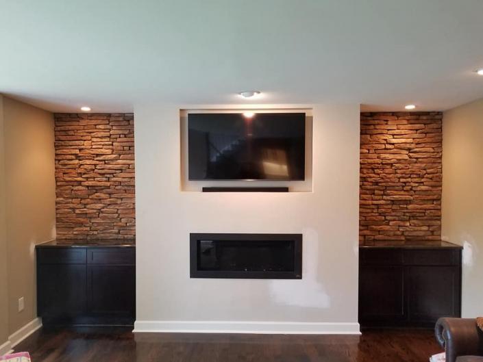 Fireplace with built in TV space and stone detailing