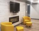 Modern basement living area with fireplace and TV