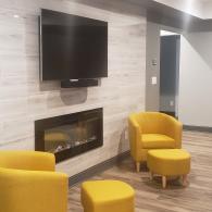 Modern basement living area with fireplace and TV