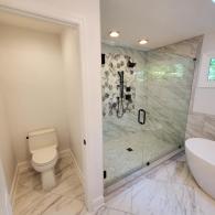 Bathroom renovation featuring modern soaking tub and glass shower