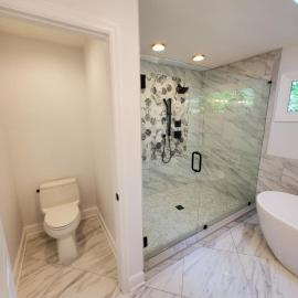 Bathroom renovation featuring modern soaking tub and glass shower