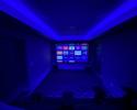 Theater room with projector screen in finished basement