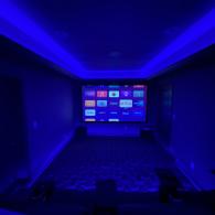 Theater room with projector screen in finished basement