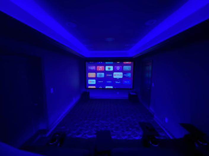 Theater room with projector screen in finished basement