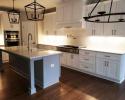White kitchen cabinets with black accents and light fixtures