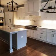 White kitchen cabinets with black accents and light fixtures